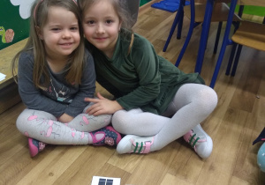 Zosia i Zuzia pozują do zdjęcia po wykonaniu zadania - złożeniu obrazka z części.
