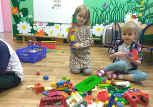 Helenka i Monika prezentują wykonane przez siebie konstrukcje z klocków Lego.