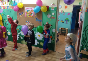 Dzieci tańczą z kolorowymi balonami.