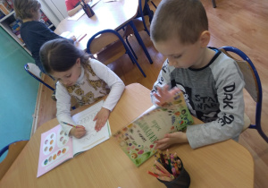 Dzieci wykonują karty pracy o tematyce świątecznej.
