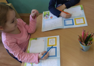 Dzieci wykonują karty pracy o tematyce świątecznej.