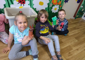 Marlena, Maksym i Wiktor prezentują prezenty dla Ziemi wykonane z okazji jej święta z materiałów recyklingowych. Rolki od papieru toaletowego pomalowane w kolorze brązowym, zielonym i czerwonym. Doklejone papierowa głowa ( wycięta i pomalowana na odpowiedni kolor, tzn. żaba na zielono, zając na brązowo, biedronka na czerwono ).