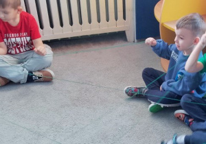 Dzieci siedzą na dywanie podając sobie kłębek wełny. Każde z dzieci trzyma swój kawałek włóczki. Zabawa pokazuje dzieciom , iż w taki sposób sieć internetowa łączy komputery na całym świecie.