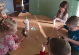 Dzieci siedzą przy stolikach, wykonując kota z rolki po papierze toaletowym. Obklejają rolkę papierem w wybranym przez siebie kolorze - białym, czarnym lub brązowym. Następnie doklejają oczy, wąsy , nos i ogon.