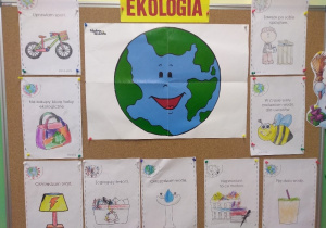 Na tablicy plakat związany z Dniem Ekologa. Pośrodku zdjęcie planety Ziemia, wokół pokolorowane przez dzieci ilustracje z napisami.