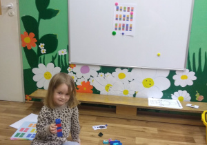 Helenka pozuje z wieżą z klocków Lego wykonaną według obrazkowej instrukcji.