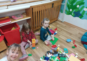 Dzieci tworzą konstrukcje z klocków Lego.