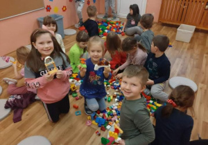 Dzieci budują konstrukcje z klocków lego.