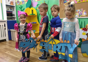 Taniec ze smokiem. Dzieci tańczą w korowodzie trzymając z boku barwnego papierowego smoka w rozmiarze xxl