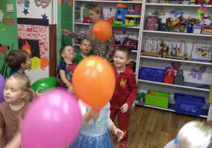 Dzieci tańczą z kolorowymi balonami.