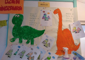 Prace dzieci z grupy 3. Dinozaury w rozmiarze xxl pomalowane farbą w kolorze zielonym i pomarańczowym