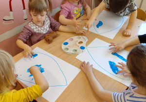 Dzieci malując palcami wypełniają farbą kontur kropli wody . Każda z prac Jest w formacie A3