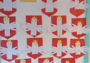 Prace wykonane przez dzieci z grupy drugiej: Godło Polski. Na czerwone kartki formatu A4, dzieci nakleiły elementy tworzące wizerunek orła białego ze złota koroną na głowie, z rozwiniętymi skrzydłami.