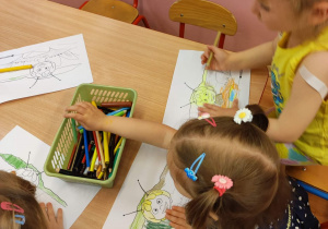 Dzieci z grupy 1 kolorują kredkami rysunek pszczółki Mai.