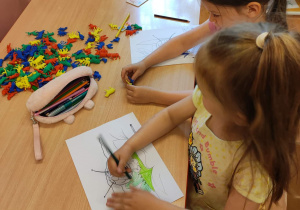 Dzieci z grupy 1 kolorują kredkami rysunek pszczółki Mai.