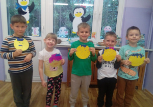 Grzesio, Viktoriia, Maksymilian, Bartuś, Szymon prezentują wykonane przez siebie uśmiechnięte buźki ( na żółtej kartce w kształcie koła dzieci namalowały oczy, nos, usta, włosy wyklejone z kawałków bibuły).