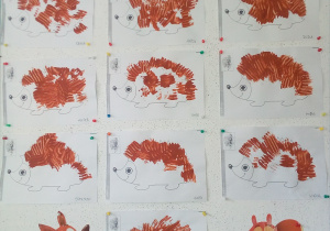 Rysunek jeża. Dzieci zanurzały widelec w brązowej farbie, a następnie odbijały go na grzbiecie narysowanego jeża, tworząc kolce.